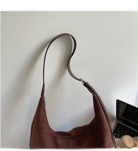 Detail view of brown faux suede hobo bag with adjustable strap and metal buckle