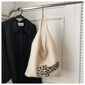 Detail of cream knit tote bag featuring leopard print letter embroidery and soft texture