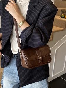 Vintage brown leather crossbody bag styled with a chic navy blue striped blazer