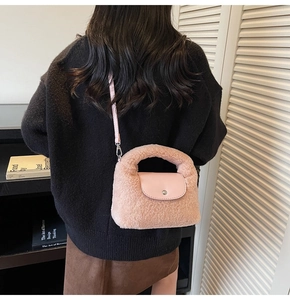 Détail d'un sac bandoulière en peluche rose clair porté par un mannequin en texture