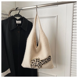 Detail of white chunky knit tote bag featuring leopard print letter and soft texture