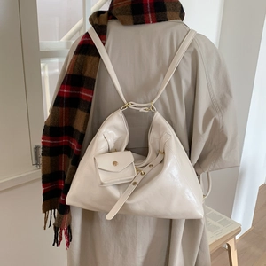Détail d'un sac cabas en cuir verni blanc cassé avec mini pochette et boucles dorées