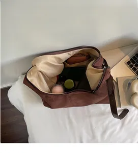 Internal view of brown suede tote bag showing large capacity and zipper closure detail