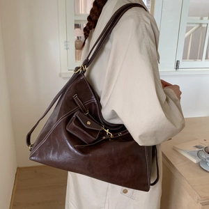 Détail du sac cabas vintage marron foncé avec surpiqûres contrastées et mini pochette