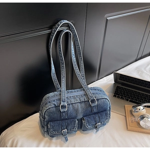Detailed macro view of vintage blue denim underarm bag with silver buckle pockets
