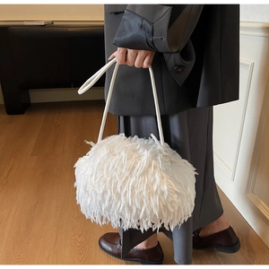 Détail du sac à bandoulière en plumes blanches avec texture douce et sangle en cuir