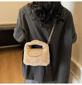 Gros plan d'un sac bandoulière en peluche avec rabat en cuir et fermoir métallique