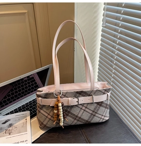 Detailed shot of plaid fabric texture and leather strap with elegant wooden bead charm