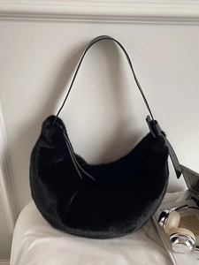 Chic black faux fur hobo shoulder bag with adjustable leather strap in a stylish setting