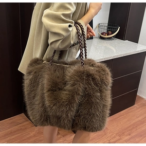 Detail der braunen Plüschtasche mit geflochtenen Ledergriffen und Reißverschluss