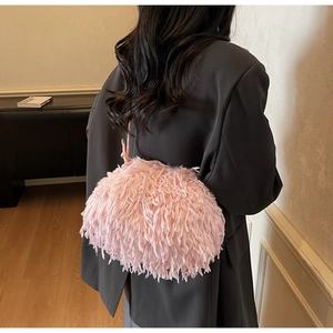 Gros plan d'un sac en peluche rose à texture de plumes sur un blazer gris chic