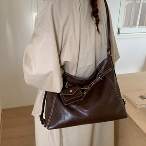 Détail du cabas vintage marron avec surpiqûres blanches et mini pochette