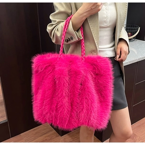 Detail der flauschigen Handtasche in Pink mit geflochtenem Riemen und Kunstfelltextur