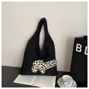 Detail of a black plush tote bag featuring a leopard print MAMA patch with gold embroidery