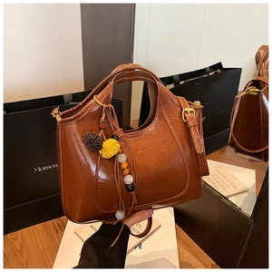 Détail du sac en cuir marron vintage avec finition brillante et reflet dans le miroir