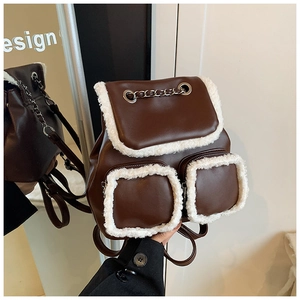 Close-up of vintage brown leather backpack featuring plush white faux fur trim and chains