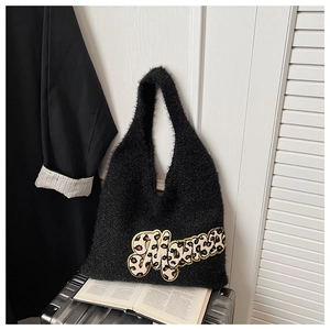 Detail of soft black plush tote bag featuring leopard print letter embroidery on luggage