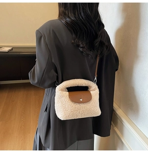 Détail du sac à main en peluche avec rabat en cuir marron porté sur un blazer