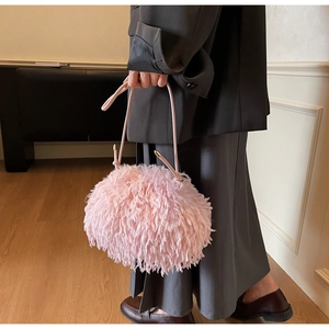 Détail d'un sac à main duveteux en fausse fourrure rose avec fines anses en cuir