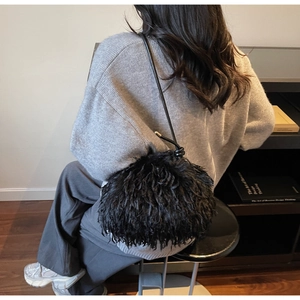 Détail du sac à bandoulière en fausse fourrure noire avec fine lanière en cuir