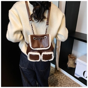 Detail showing the brown leather backpack with white faux fur trim and dual front pockets