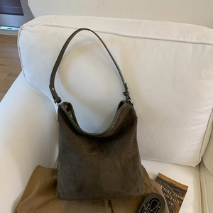 Detail view of the matte suede hobo bucket bag with central decorative stitching