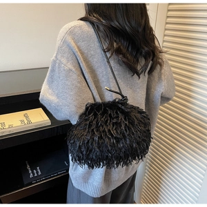 Détail de la texture en plumes noires et de la bandoulière nouée du sac à bandoulière