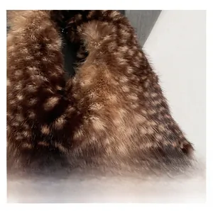 Dettaglio della pelliccia sintetica e della tracolla a catena in metallo della borsa