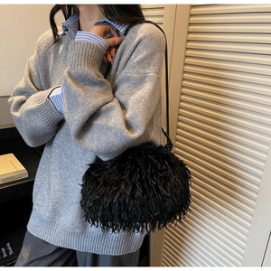 Détail du sac à bandoulière en plumes noires duveteuses avec bandoulière en cuir