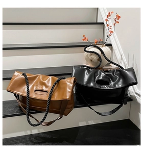 Detail of minimalist tote bags with unique thick rope straps on modern stairs
