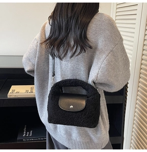 Détail du sac en fausse fourrure noire avec rabat en cuir et fermoir magnétique argenté