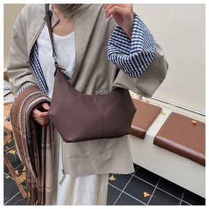 Détail du sac croissant marron vintage montrant les coutures et le similicuir mat