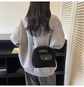 Détail d'un sac bandoulière en fausse fourrure noire avec rabat en cuir et fermoir argenté
