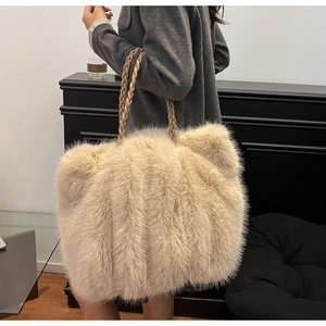 Detail der beigen Plüschtasche mit geflochtenem Griff und goldenem Reißverschluss