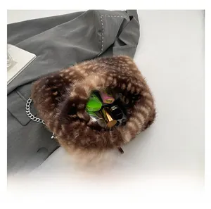 Dettaglio della borsa a tracolla in peluche aperta che mostra la capacità per il trucco