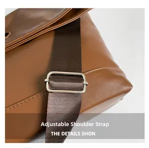 Detail of adjustable nylon shoulder strap and silver metal buckle on brown leather bag