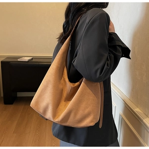 Detailed texture of khaki suede large tote bag worn over the shoulder by a model