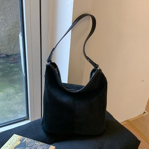 Detailed view of the matte black faux suede hobo bag with slim shoulder strap