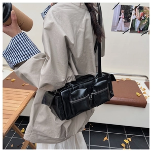 Fashionable black multi-pocket shoulder bag in matte PU leather shown in lifestyle use