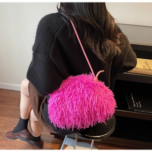 Vue détaillée du sac à bandoulière rose fuchsia en fausse fourrure douce sur un modèle