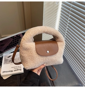 Détail du sac en peluche beige avec rabat en cuir marron et bandoulière amovible