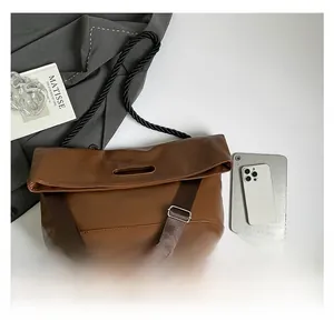Flat lay of brown leather tote bag with thick woven rope handles and wide canvas strap
