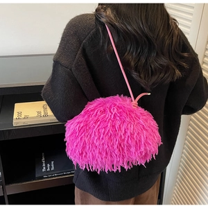 Vue de dos d'un mannequin portant un sac bandoulière en peluche rose vif avec franges
