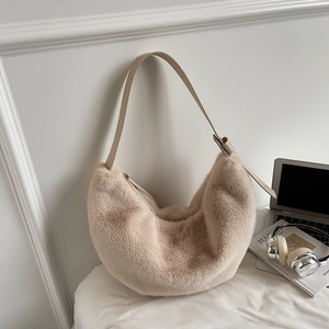 Detail of plush beige dumpling bag with faux fur texture and adjustable strap