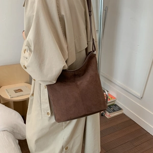 Detail of a large brown frosted vintage bucket bag for women worn over the shoulder