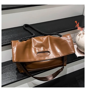 Brown soft leather tote bag detail with double straps and black woven rope handle