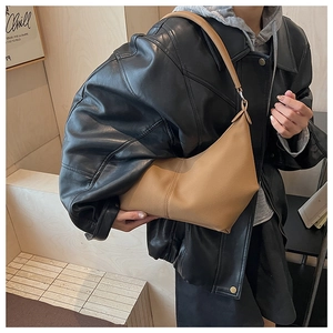 Détail du sac hobo en cuir marron kaki avec coutures et large bandoulière à l'épaule