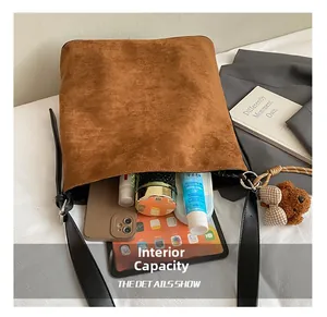 Detail view of large brown suede bucket bag interior capacity with daily essentials