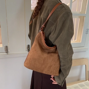 Close-up of vintage brown hobo bag in matte suede with adjustable leather shoulder strap