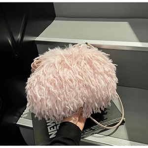 Détail du sac à plumes roses montrant sa texture douce et sa bandoulière élégante